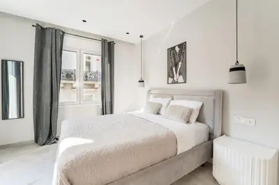 a white bedroom with a bed and a window at Luna Luxury Suite - close to Acropolis in Athens
