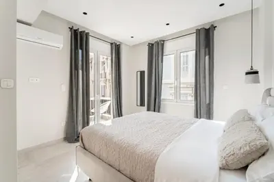 a white bedroom with a large bed and windows at Luna Luxury Suite - close to Acropolis in Athens