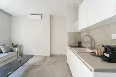 a kitchen with white cabinets and a sink at Luna Luxury Suite - close to Acropolis in Athens