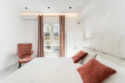 a bedroom with a white bed and a chair at Honey Luxury Suite - close to Acropolis in Athens