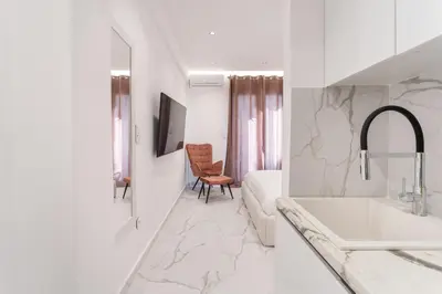 a white bathroom with a sink and a bath tub at Honey Luxury Suite - close to Acropolis in Athens