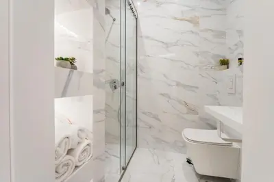 a bathroom with white marble walls and a glass shower at Honey Luxury Suite - close to Acropolis in Athens