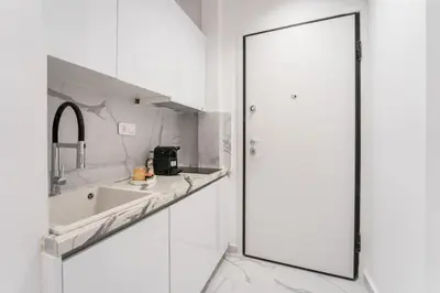 a white kitchen with a sink and a mirror at Honey Luxury Suite - close to Acropolis in Athens