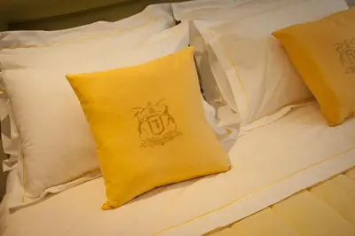 a bed with white pillows and a yellow pillow at Acropolis Luxury Apartment in Athens