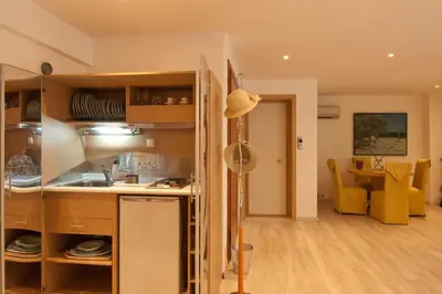 a kitchen and living room with a table and yellow chairs at Acropolis Luxury Apartment in Athens