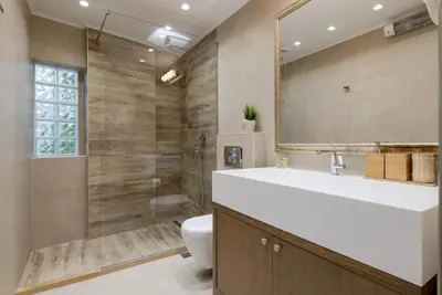 a bathroom with a sink and a toilet and a mirror at Artemis - Luxenia Suites in Athens