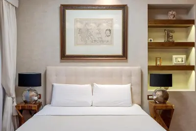 a bedroom with a white bed with two night stands at Artemis - Luxenia Suites in Athens