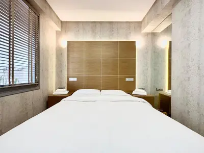 a bedroom with a large bed and a large window at Demetra-Luxenia Suites Athens in Athens