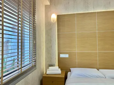 a bedroom with two beds and a window at Demetra-Luxenia Suites Athens in Athens