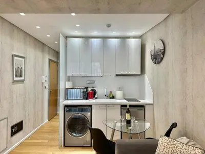 a kitchen with a washing machine and a glass table at Demetra-Luxenia Suites Athens in Athens