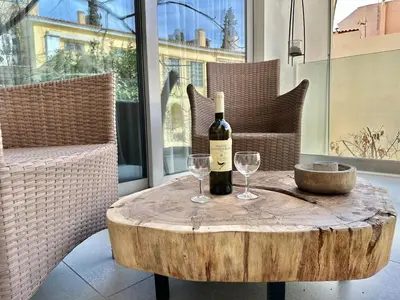 a bottle of wine and two glasses on a table at Demetra-Luxenia Suites Athens in Athens
