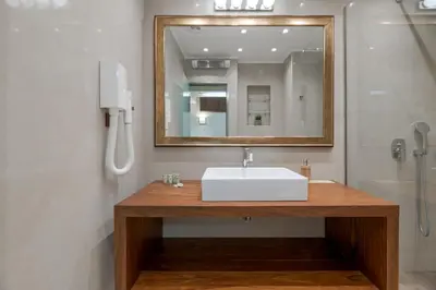 a bathroom with a white sink and a mirror at Zeus - Luxenia Suites in Athens