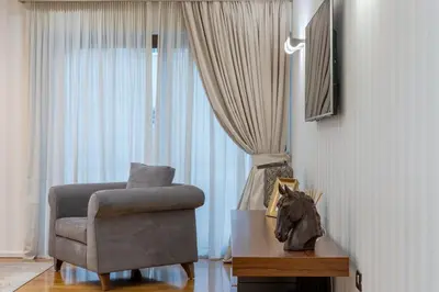 a living room with a chair and a table at Zeus - Luxenia Suites in Athens