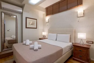 a bedroom with a large bed and a mirror at Zeus - Luxenia Suites in Athens