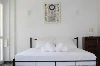 a bed with white sheets and pillows in a room at Ionos Dragoumi 34 Athens Comfy Studio in Athens