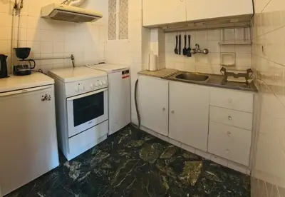a small kitchen with white cabinets and a sink at Ionos Dragoumi 34 Athens Comfy Studio in Athens