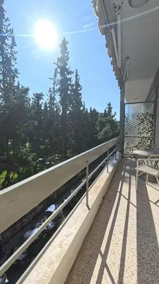a balcony with a bench and the sun in the sky at Ionos Dragoumi 34 Athens Comfy Studio in Athens