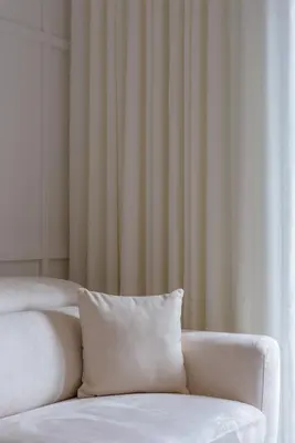 a white couch with a pillow in front of a window at Apollo - Luxenia Suites in Athens