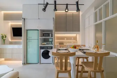 a kitchen with a table and chairs and a refrigerator at Apollo - Luxenia Suites in Athens