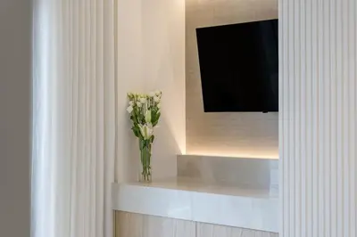 a vase of flowers sitting on a shelf in a room at Apollo - Luxenia Suites in Athens