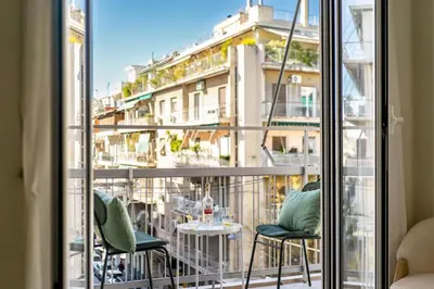a balcony with chairs and a table and a building at Spacious 2BR in Koukaki l Balcony l Near Acropolis in Athens