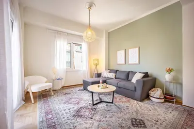 a living room with a couch and a table at Spacious 2BR in Koukaki l Balcony l Near Acropolis in Athens