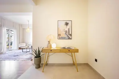 a desk in a living room with a picture on the wall at Spacious 2BR in Koukaki l Balcony l Near Acropolis in Athens