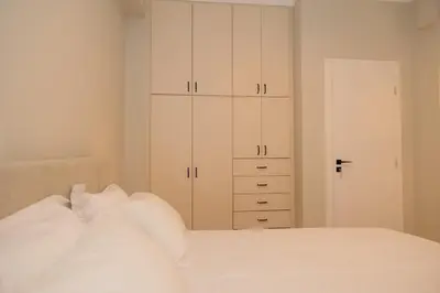 a bedroom with white cabinets and a white bed at Vintage-Inspired 2BDR Apt - 15' to Monastiraki in Athens