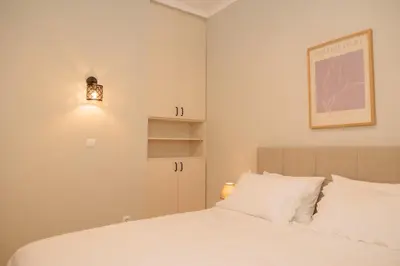 a bedroom with a white bed and a picture on the wall at Vintage-Inspired 2BDR Apt - 15' to Monastiraki in Athens