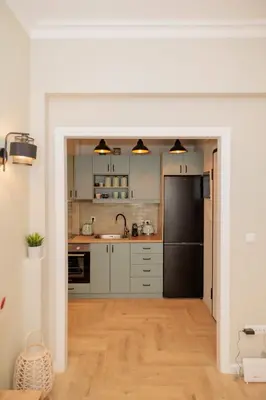 a kitchen with white cabinets and a black refrigerator at Vintage-Inspired 2BDR Apt - 15' to Monastiraki in Athens