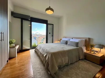 a bedroom with a large bed and a large window at Acropolis Cityscape Loft in Athens