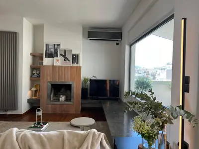 a living room with a fireplace and a large window at Acropolis Cityscape Loft in Athens