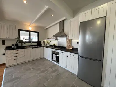 a kitchen with white cabinets and a stainless steel refrigerator at Acropolis Cityscape Loft in Athens