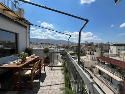 a patio with a table and chairs on a balcony at Acropolis Cityscape Loft in Athens