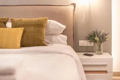 a bed with a vase of flowers on a night stand at Marina Zeas Comfy Apartment in Piraeus