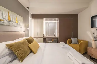 a bedroom with a large white bed and a chair at Marina Zeas Comfy Apartment in Piraeus