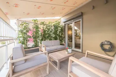 a patio with chairs and a table on a balcony at Marina Zeas Comfy Apartment in Piraeus
