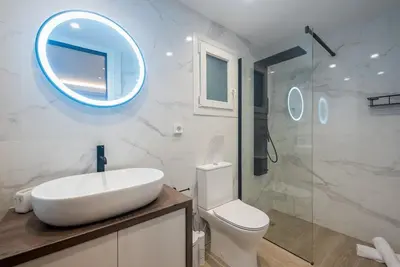 a bathroom with a sink and a toilet and a mirror at Marina Zeas Comfy Apartment in Piraeus