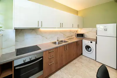 a kitchen with a sink and a white refrigerator at The Faliro Oasis in Athens
