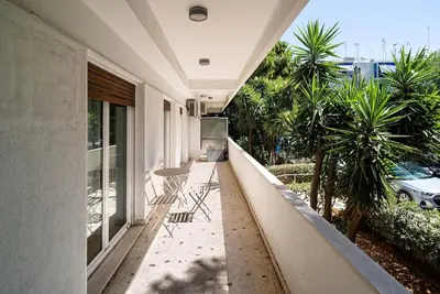 a balcony of a house with chairs and trees at The Faliro Oasis in Athens