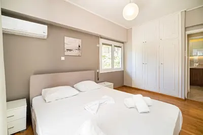 a bedroom with a white bed with two towels on it at The Faliro Oasis in Athens