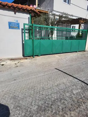 a green gate on the side of a building at Maria guesthouse in Spáta