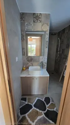 a bathroom with a sink and a mirror and a rug at Maria guesthouse in Spáta