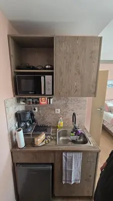 a small kitchen with a sink and a microwave at Maria guesthouse in Spáta