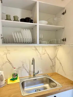 a kitchen counter with a sink and white cabinets at Athens Platonos Appartment in Athens