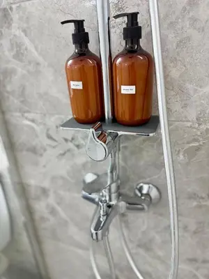 two bottles of soap on a shelf next to a sink at Athens Platonos Appartment in Athens