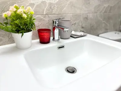 a bathroom sink with a faucet and flowers on it at Athens Platonos Appartment in Athens