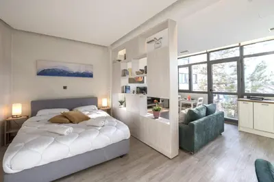 a bedroom with a large white bed and a green chair at Luxury Haven in the most ideal area of Athens in Athens