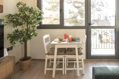 a table and chairs in a living room with a plant at Luxury Haven in the most ideal area of Athens in Athens