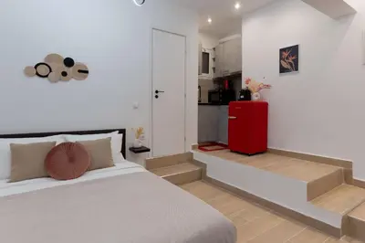 a bedroom with a bed and a red refrigerator at ARIS- Queen suite on the boulevard in Athens